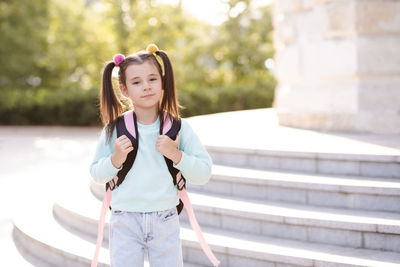 Smiling sweet happy little kid girl 5-6 year old wear casual clothes and backpack. pupil child