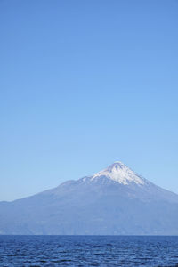 Scenic view of snowcapped vulcano against clear blue sky