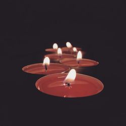 Close-up of illuminated tea light in darkroom