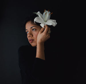 Close-up of woman against black background