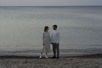 Rear view of couple standing on beach