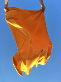 Low angle view of flags against clear blue sky