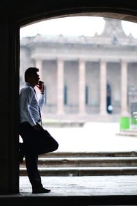 Full length of man standing on mobile phone