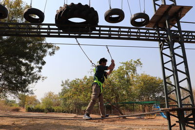 Full length of man playing soccer against sky