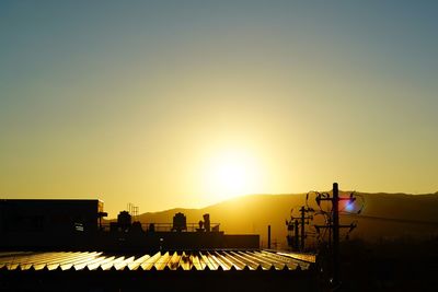 Silhouette city against clear sky during sunset