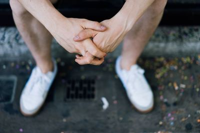 Low section of man sitting on footpath