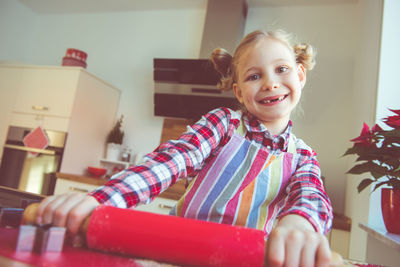 Smiling girl making cookies at home