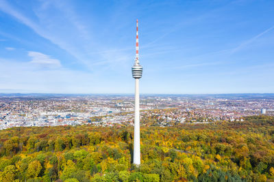 Tower amidst trees and buildings in city against sky