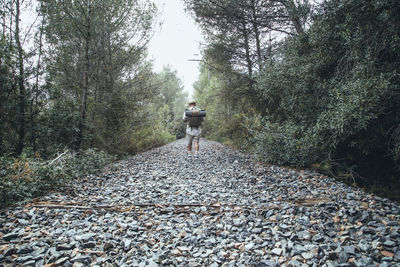 Rear view of man standing in forest