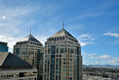 Low angle view of buildings against cloudy sky