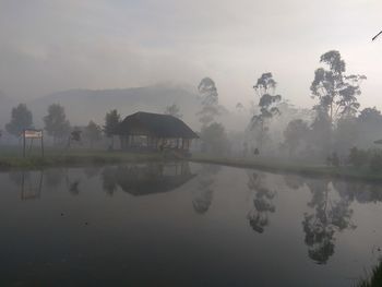 Scenic view of lake against sky during foggy weather