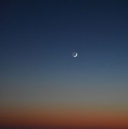 Low angle view of moon against clear blue sky