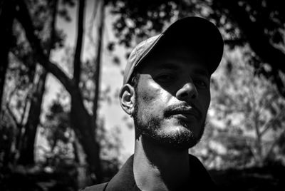 Portrait of young man against tree