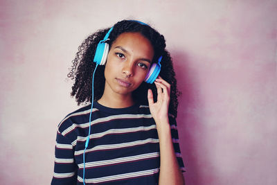 Portrait of beautiful woman standing against wall