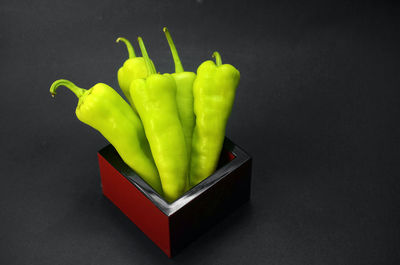 Close-up of green chili pepper against black background