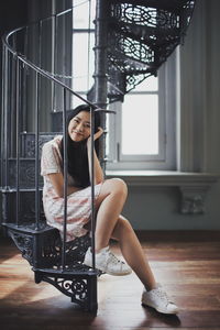 Portrait of woman sitting on floor at home