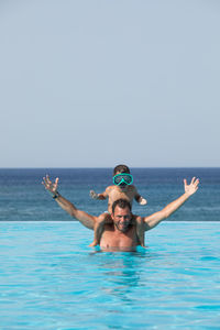 Portrait of man with swimming pool in sea against clear sky