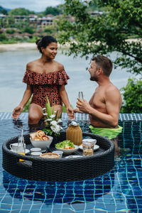 Rear view of woman holding food at beach