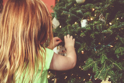 Rear view of girl decorating christmas tree