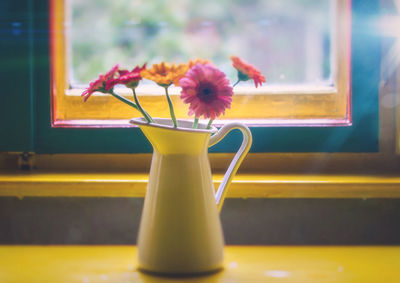 Close-up of flower vase on window sill