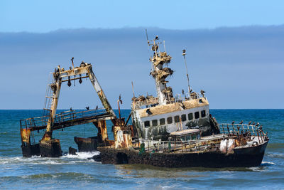 Abandoned ship in sea against sky