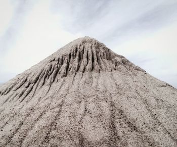 Low angle view of volcanic mountain against sky