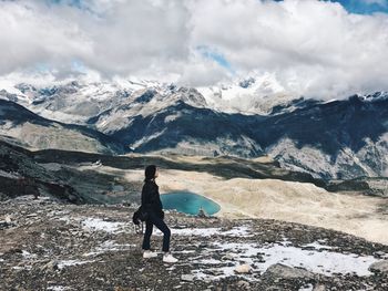 Rear view of woman walking on snowcapped mountain