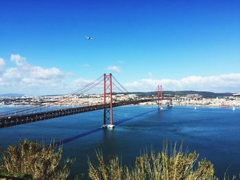 25 de abril bridge over tagus river against sky in city