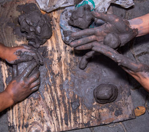 Close-up of hands holding clay on table