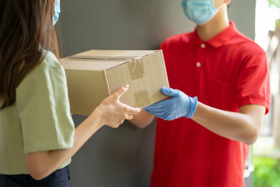 Rear view of woman holding red box