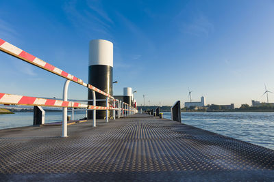 Pier over sea against clear blue sky