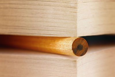 Close-up of wooden stick amidst pages in book
