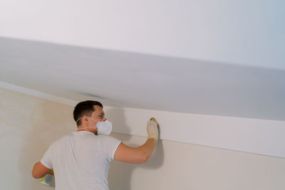 Portrait of young woman standing against wall