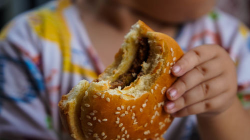 Close-up of baby holding hamburger