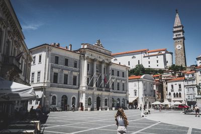 Rear view of woman standing at tartini square during sunny day