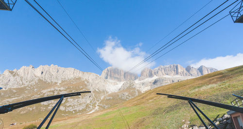 Overhead cable car over mountains against sky