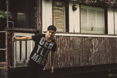 Full length of young man standing against building