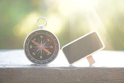 Close-up of navigational compass and slate on table