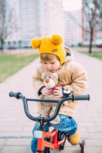 A small child learns to ride a bike for the first time in the city in spring