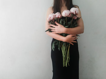 Midsection of woman standing against wall