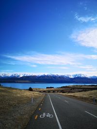 Road leading towards mountains against sky