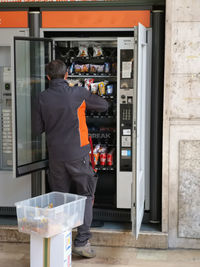 Rear view of man standing at store