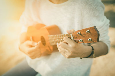 Midsection of man playing guitar