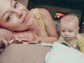 Portrait of mother with baby boy on bed at home