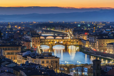 High angle view of illuminated bridge and buildings against sky at sunset