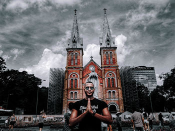 Portrait of man against illuminated building against sky