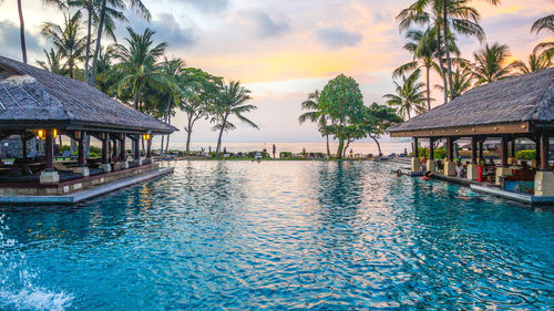 Swimming pool by sea against sky