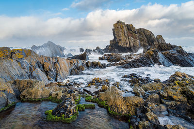 Scenic view of rock formations in sea against sky