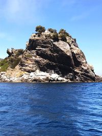 Scenic view of cliff and sea against clear blue sky