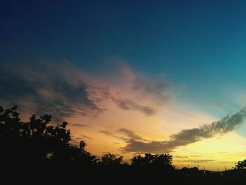 Low angle view of silhouette trees against sky at sunset